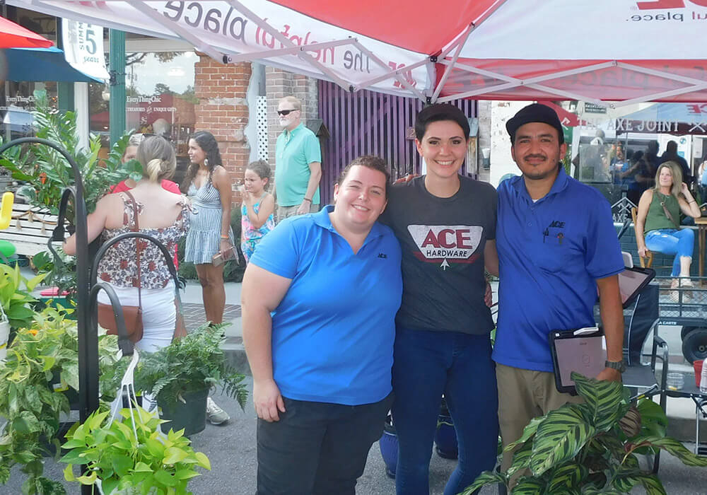 Local shop staff greet visitors at their booth