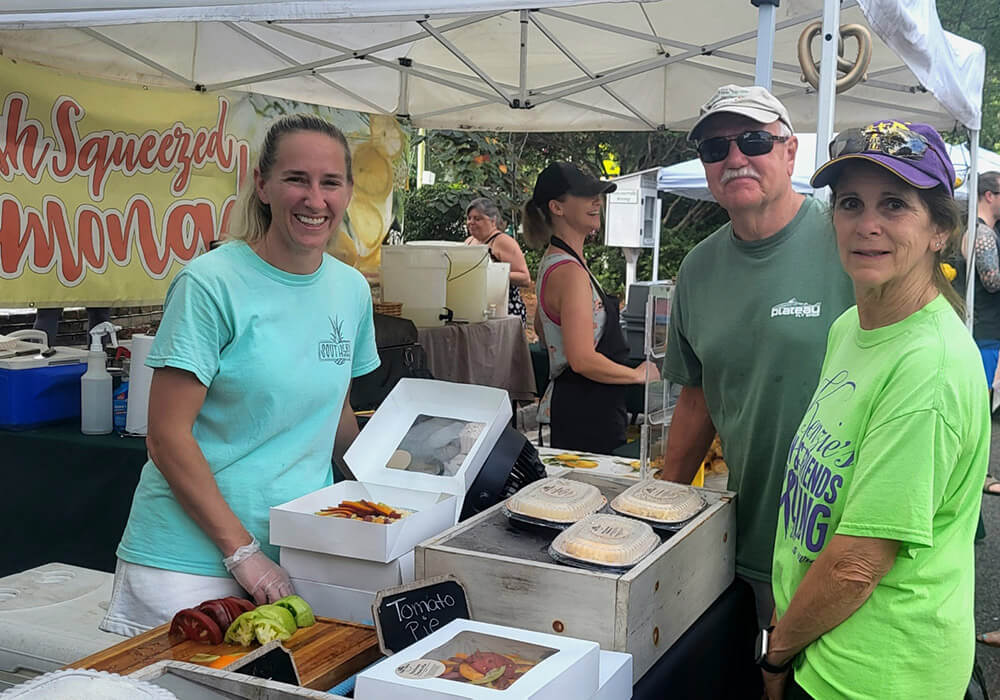A vendor sells tomato pies beside a fresh squeezed lemonade stand